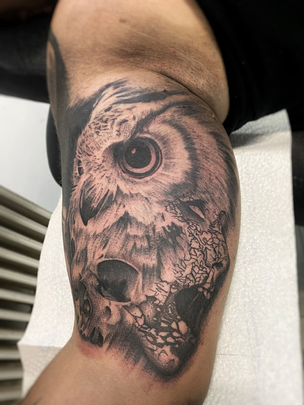 Black and Grey Cover-Up Tattoo am Oberarm: Eule mit Totenkopf